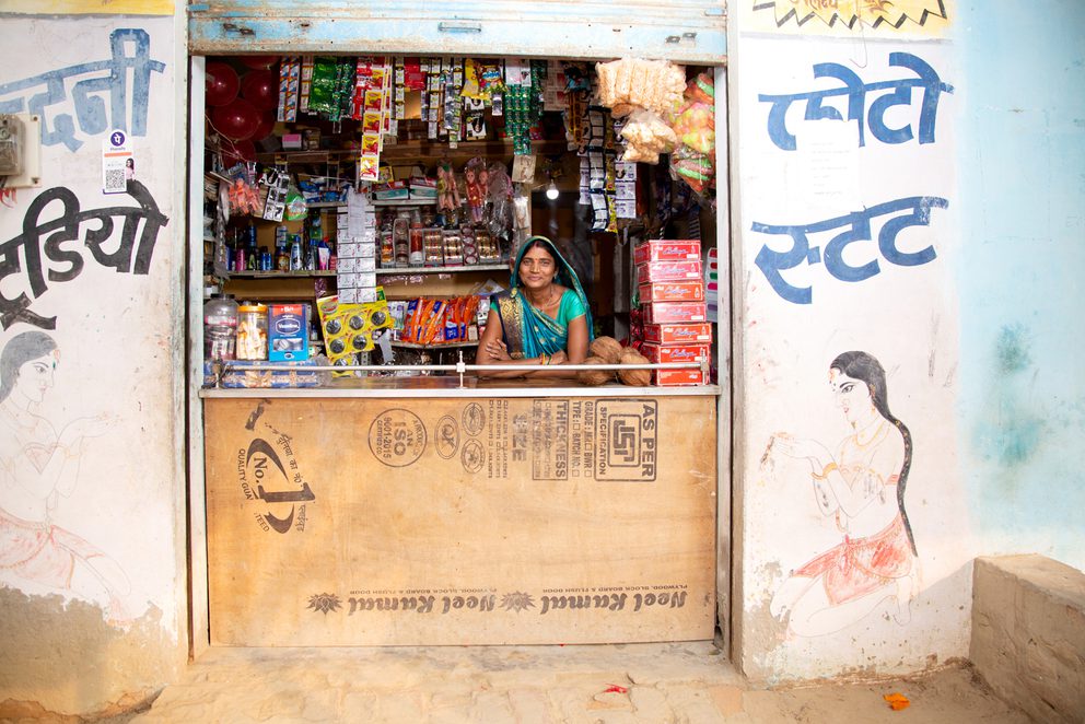 Smiling woman sat behind shop counter
