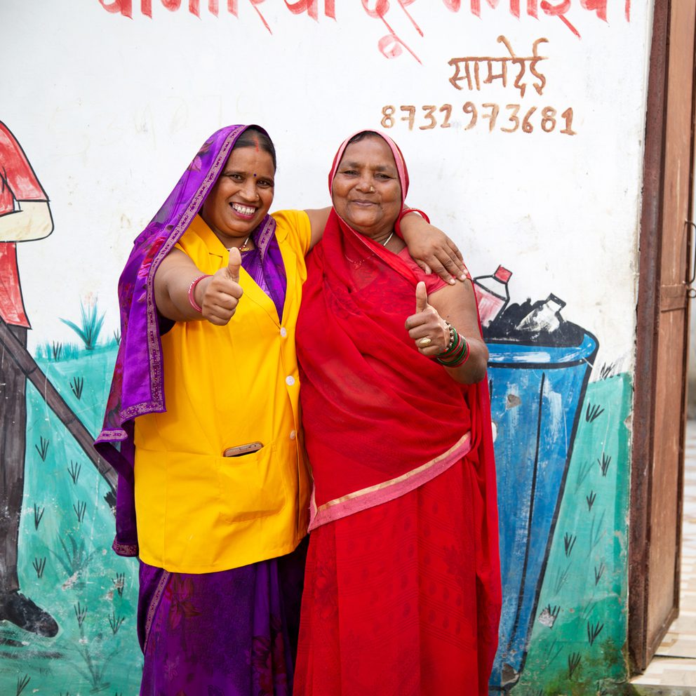 Smiling women giving thumbs up