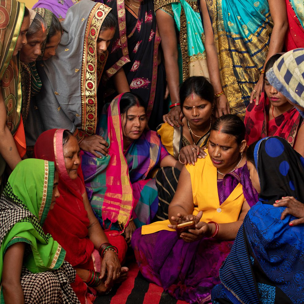 Women gathered around a phone watching intently